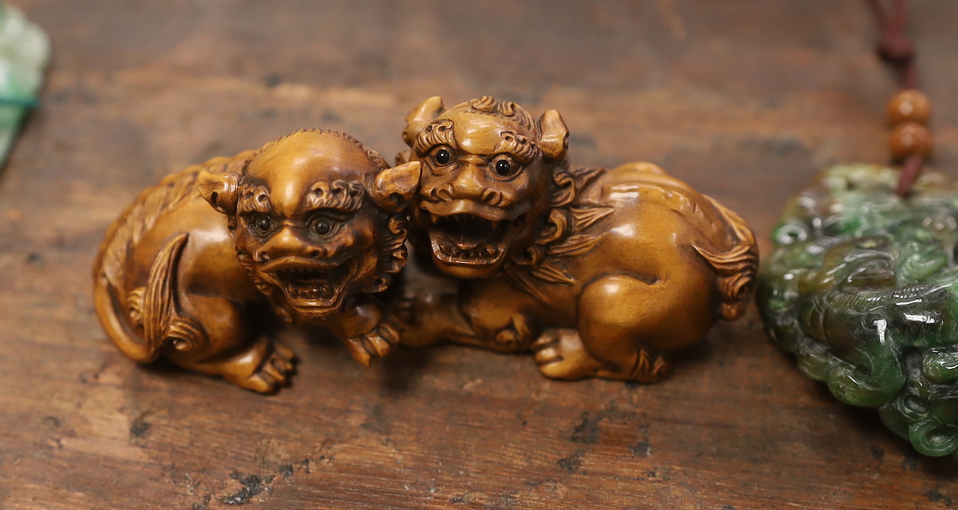 Five Chinese jadeite pendants and two wood lion-dog netsuke, netsuke 3.5 high